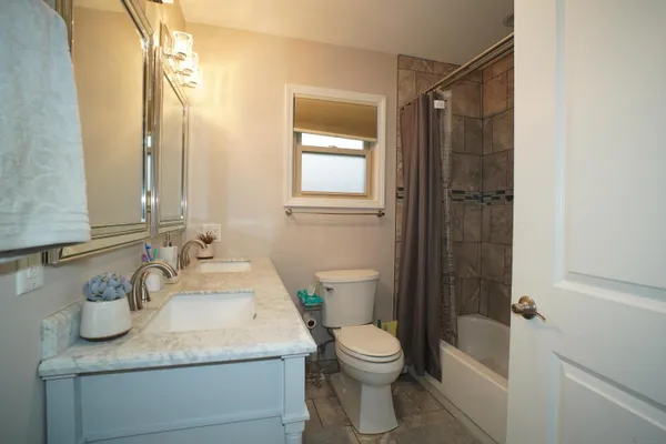a bathroom with a granite countertop sink toilet and shower