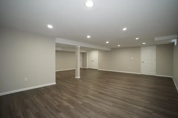 an empty room with wooden floor and natural light