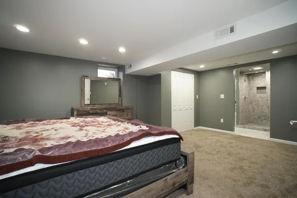 a bedroom with a bed and a large mirror