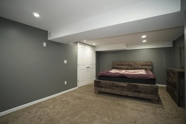 a spacious bedroom with a bed and a night stand