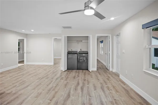 a view of a kitchen with wooden floor a sink and a refrigerator