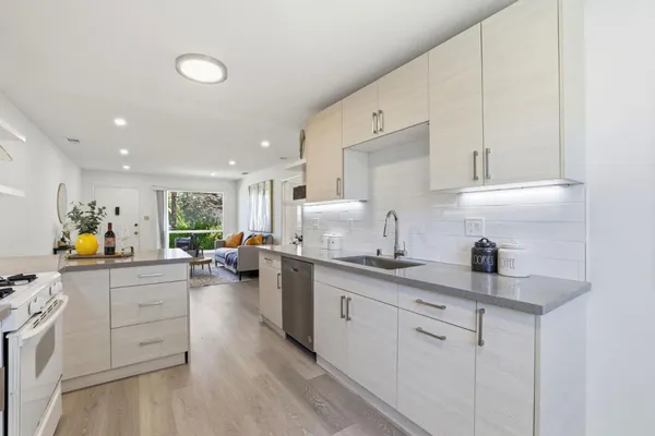 a kitchen with counter top space sink stove and cabinets