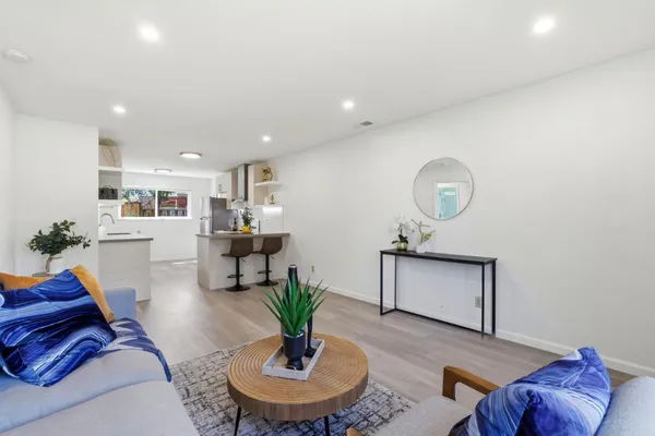 a living room with furniture kitchen and a table