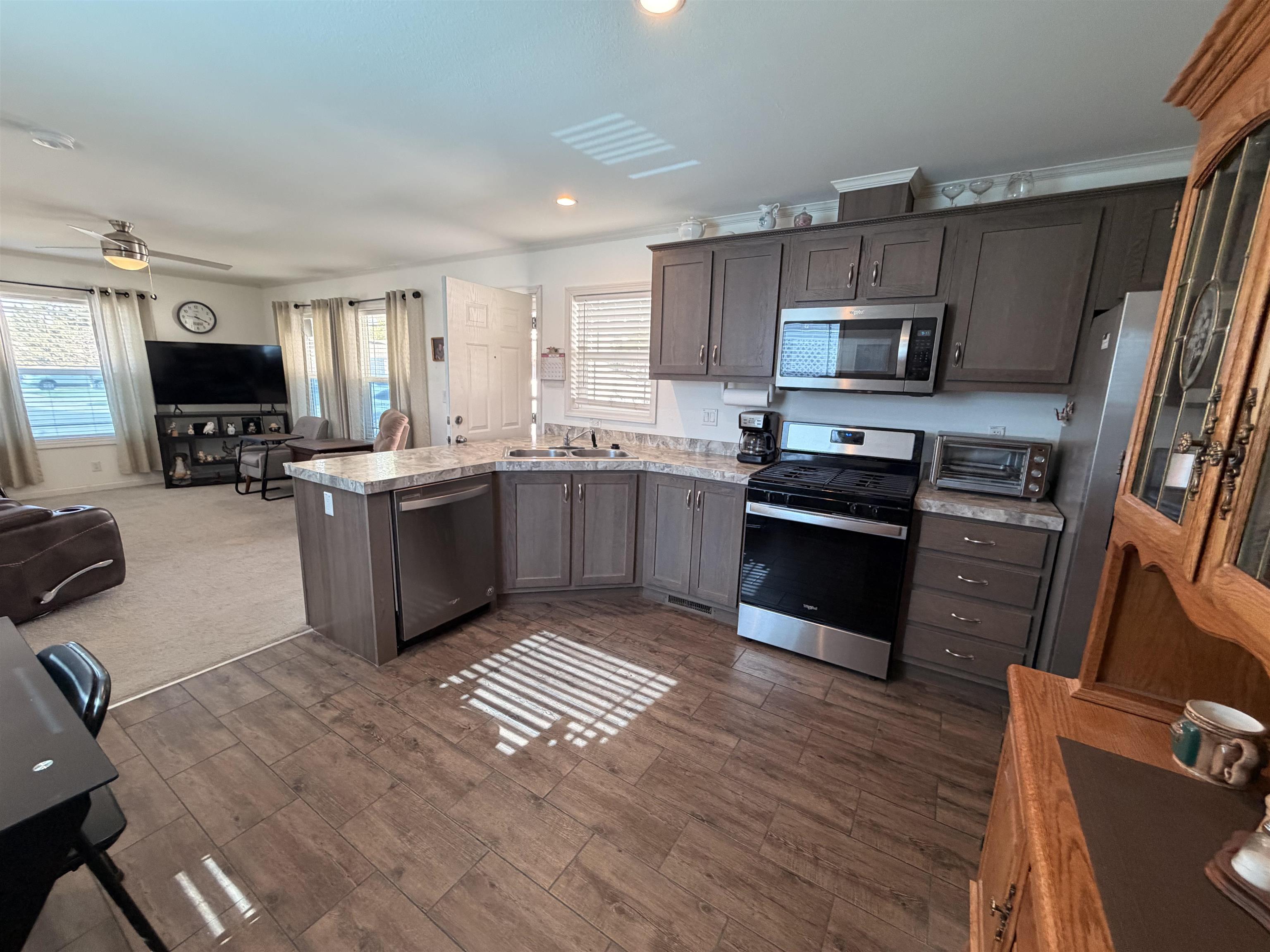 435 32 Road, Unit 826 Clifton, CO 81520 - Photo 6 of 17 a kitchen with stainless steel appliances granite countertop a stove top oven a sink dishwasher a refrigerator and a microwave