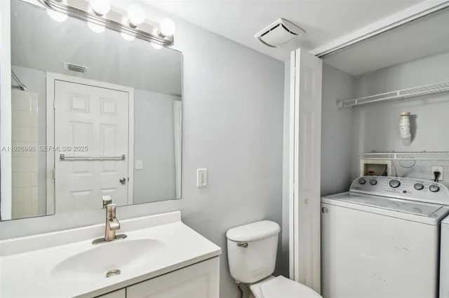 a bathroom with a granite countertop sink a toilet and shower