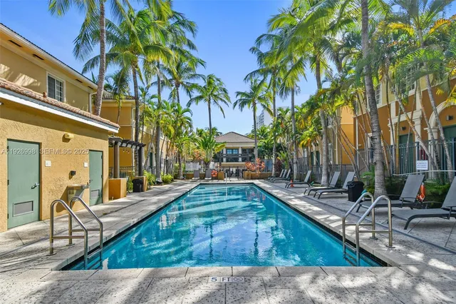 a row of palm trees and dinning table with chairs in patio
