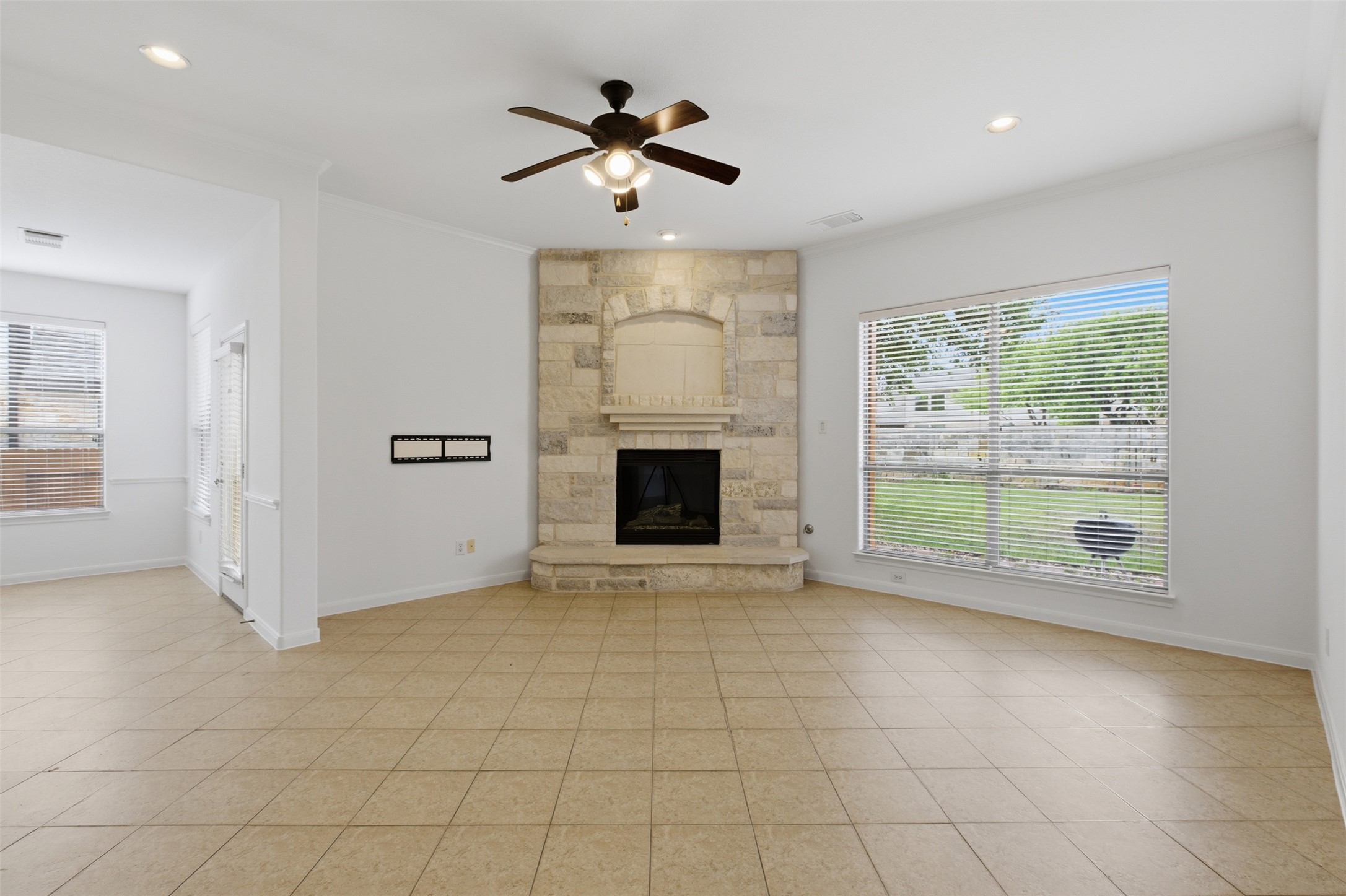 2909 Agave Loop Round Rock, TX 78681 - Photo 14 of 38 Family room featuring a ceiling fan, ornamental molding, a fireplace, recessed lighting, and light tile patterned floors