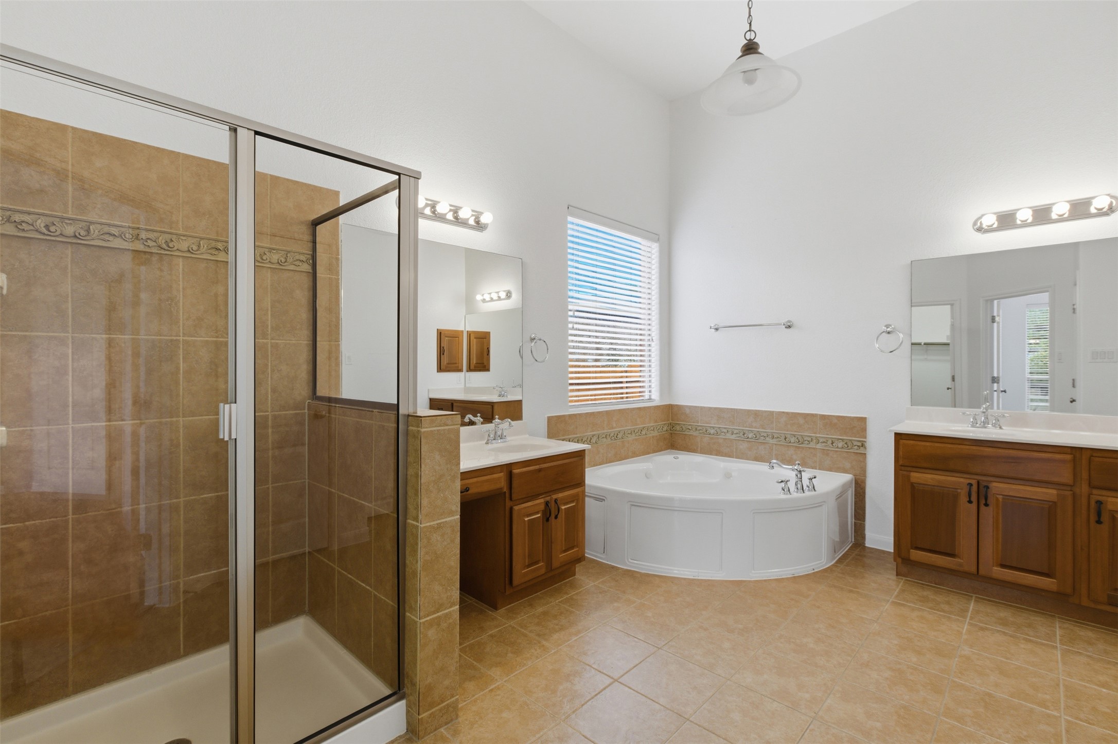 2909 Agave Loop Round Rock, TX 78681 - Photo 17 of 38 Full Master bath featuring a garden tub, a stall shower, two vanities, and light tile patterned flooring