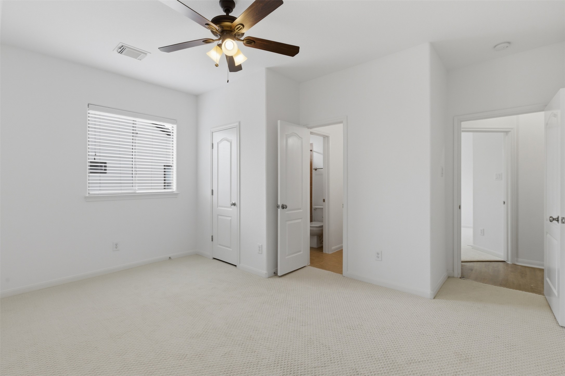 2909 Agave Loop Round Rock, TX 78681 - Photo 27 of 38 Bedroom 4 with light carpet, connected bathroom, and a ceiling fan
