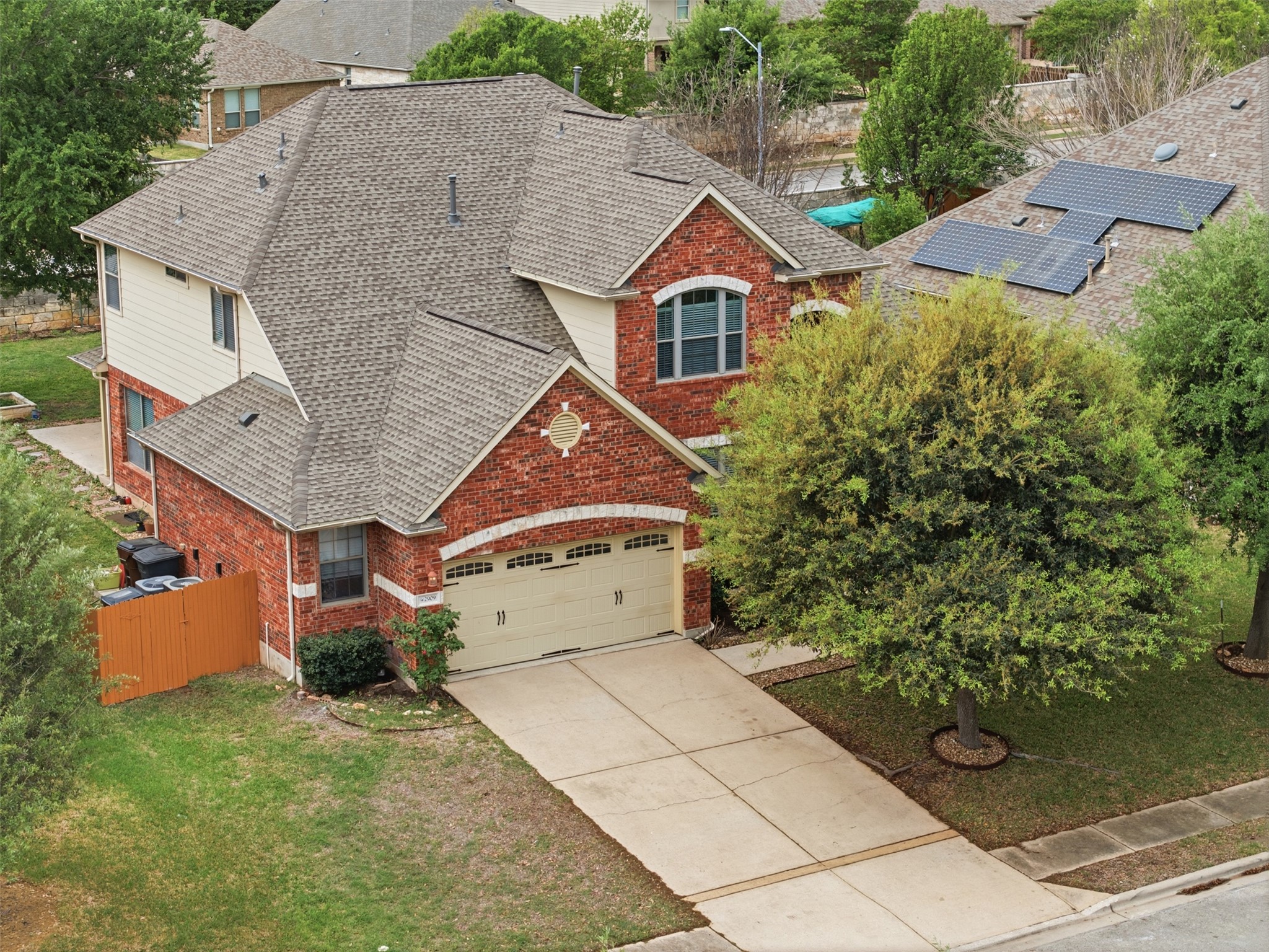 2909 Agave Loop Round Rock, TX 78681 - Photo 3 of 38 Traditional-style house with roof with shingles, brick siding, driveway, roof mounted solar panels, and a 2.5 garage