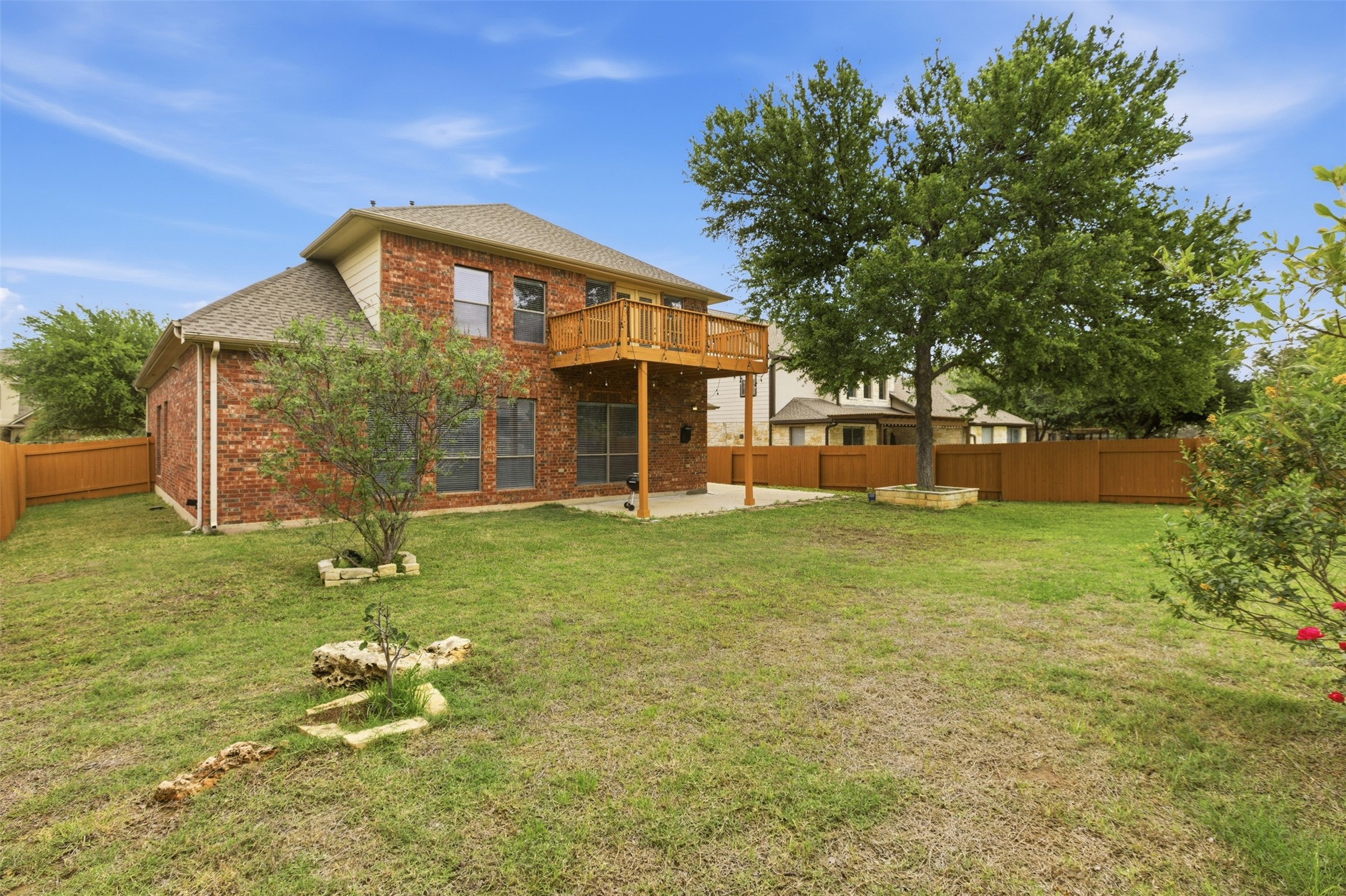 2909 Agave Loop Round Rock, TX 78681 - Photo 35 of 38 Rear view of house featuring Balcony, a patio area, brick siding, a fenced backyard, a shingled roof, and a wooden deck