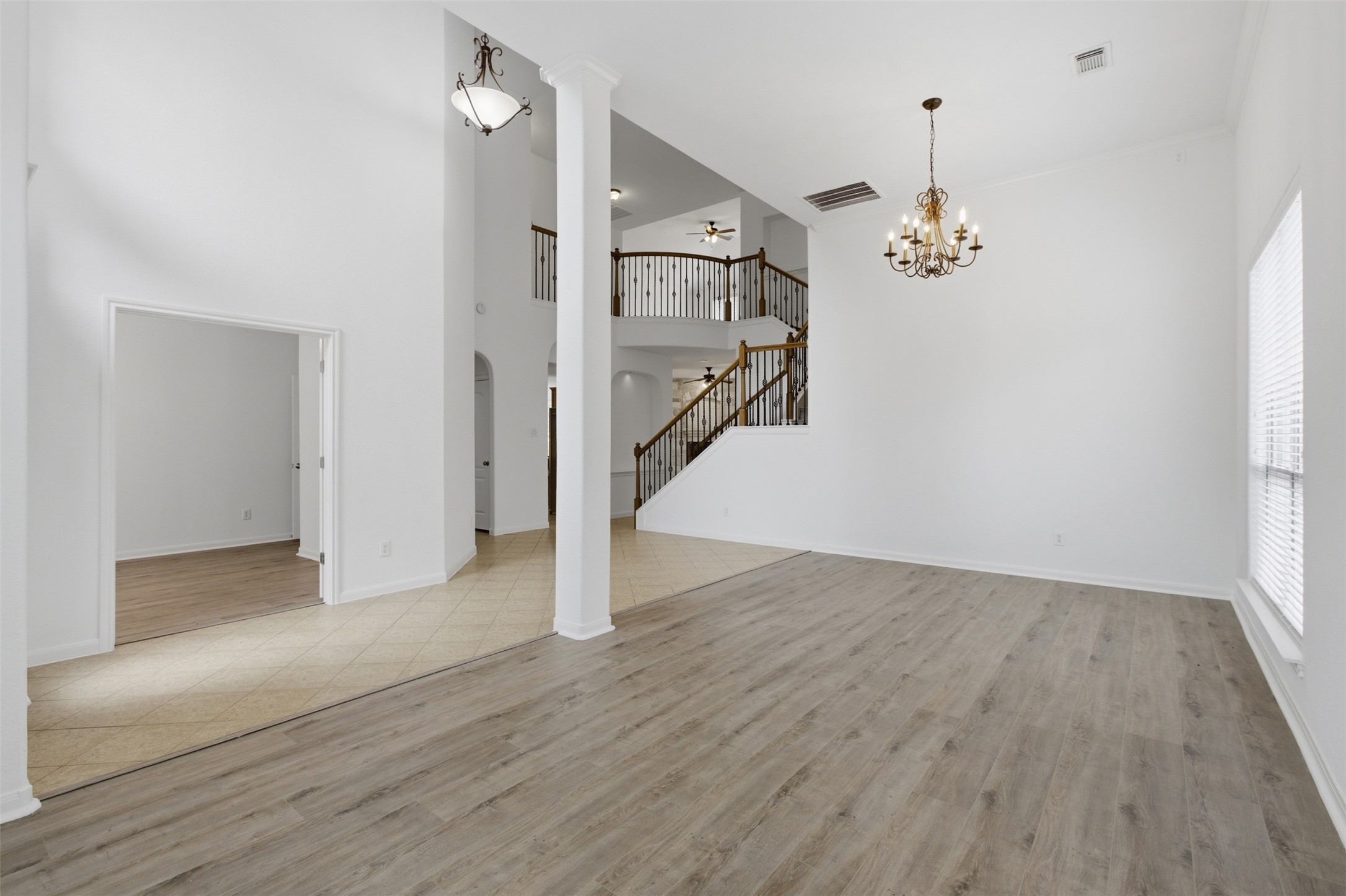 2909 Agave Loop Round Rock, TX 78681 - Photo 5 of 38 Living room & Formal Dining room a high ceiling, light wood-style floors, a chandelier, a ceiling fan, and arched walkways