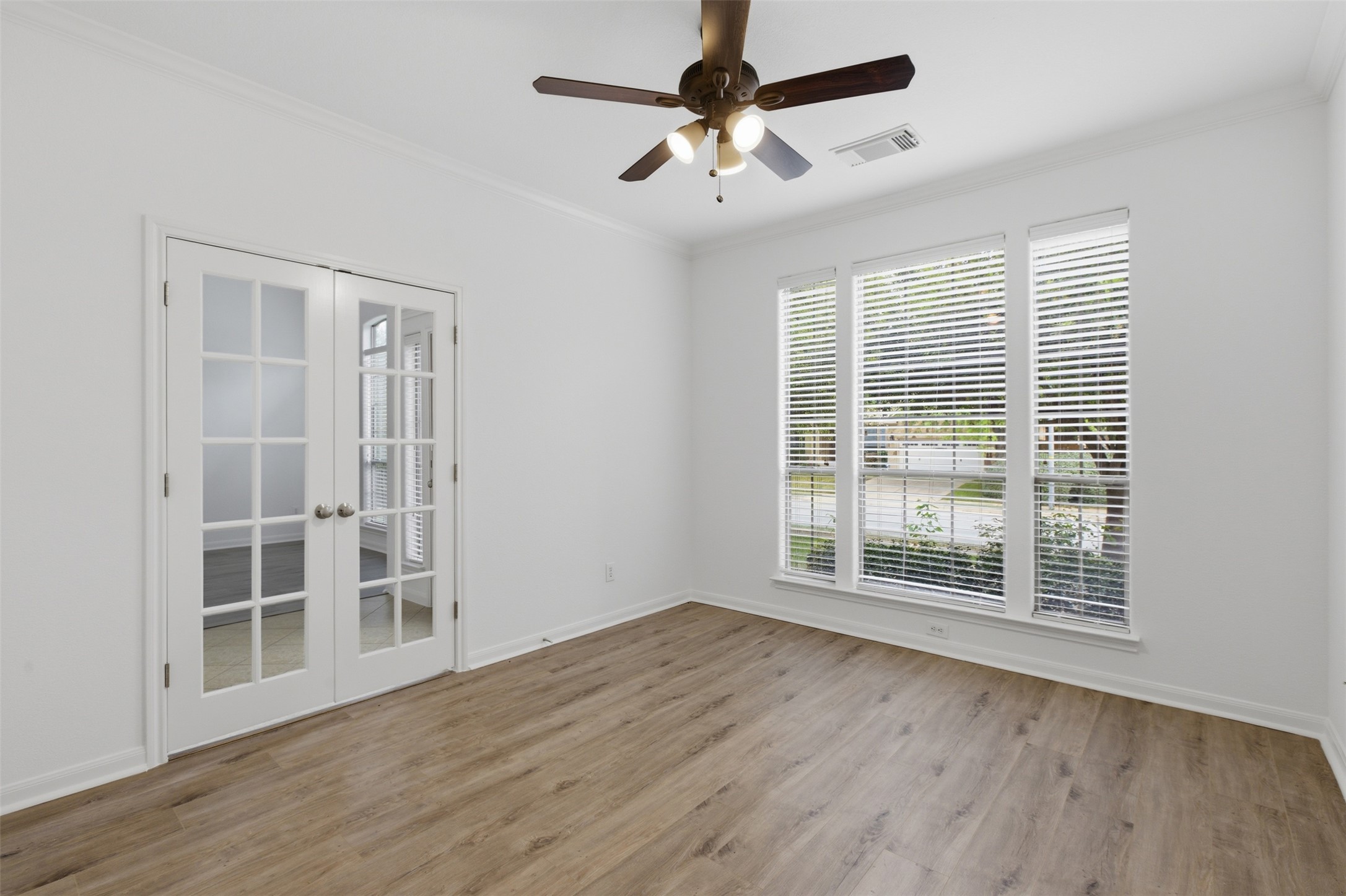 2909 Agave Loop Round Rock, TX 78681 - Photo 6 of 38 Study/Bedroom 2 room with french doors, a ceiling fan, crown molding, and light wood-style flooring
