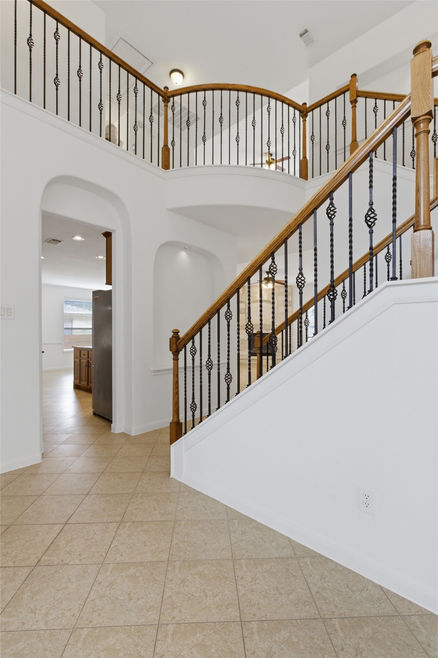 2909 Agave Loop Round Rock, TX 78681 - Photo 8 of 38 Staircase featuring arched walkways, a high ceiling, and tile patterned floors