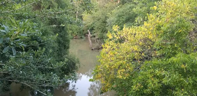 a view of a patio with chairs and table under an umbrella
