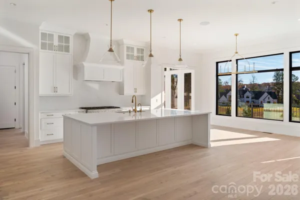 a view of kitchen with stainless steel appliances granite countertop a sink a window and a refrigerator