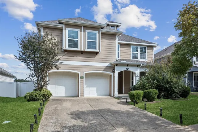 a front view of a house with garden and parking