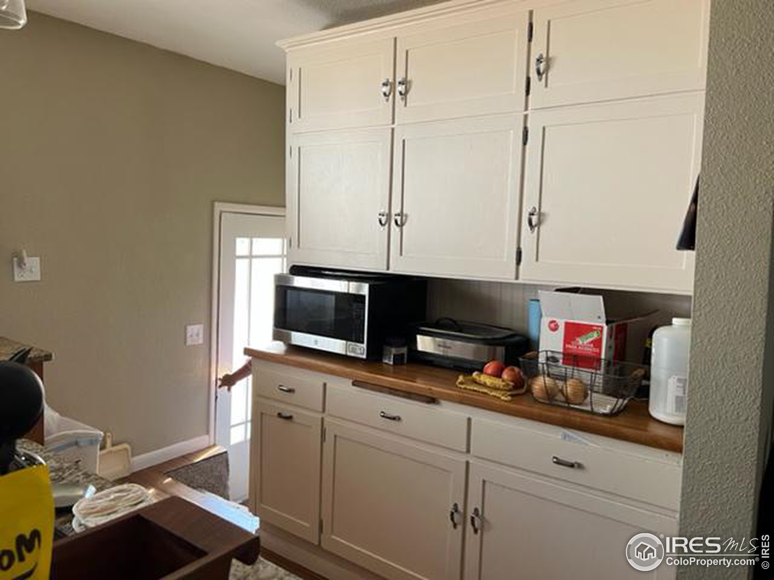 1124 West 7th Street Wray, CO 80758 - Photo 8 of 11 a kitchen with stainless steel appliances white cabinets and a stove top oven