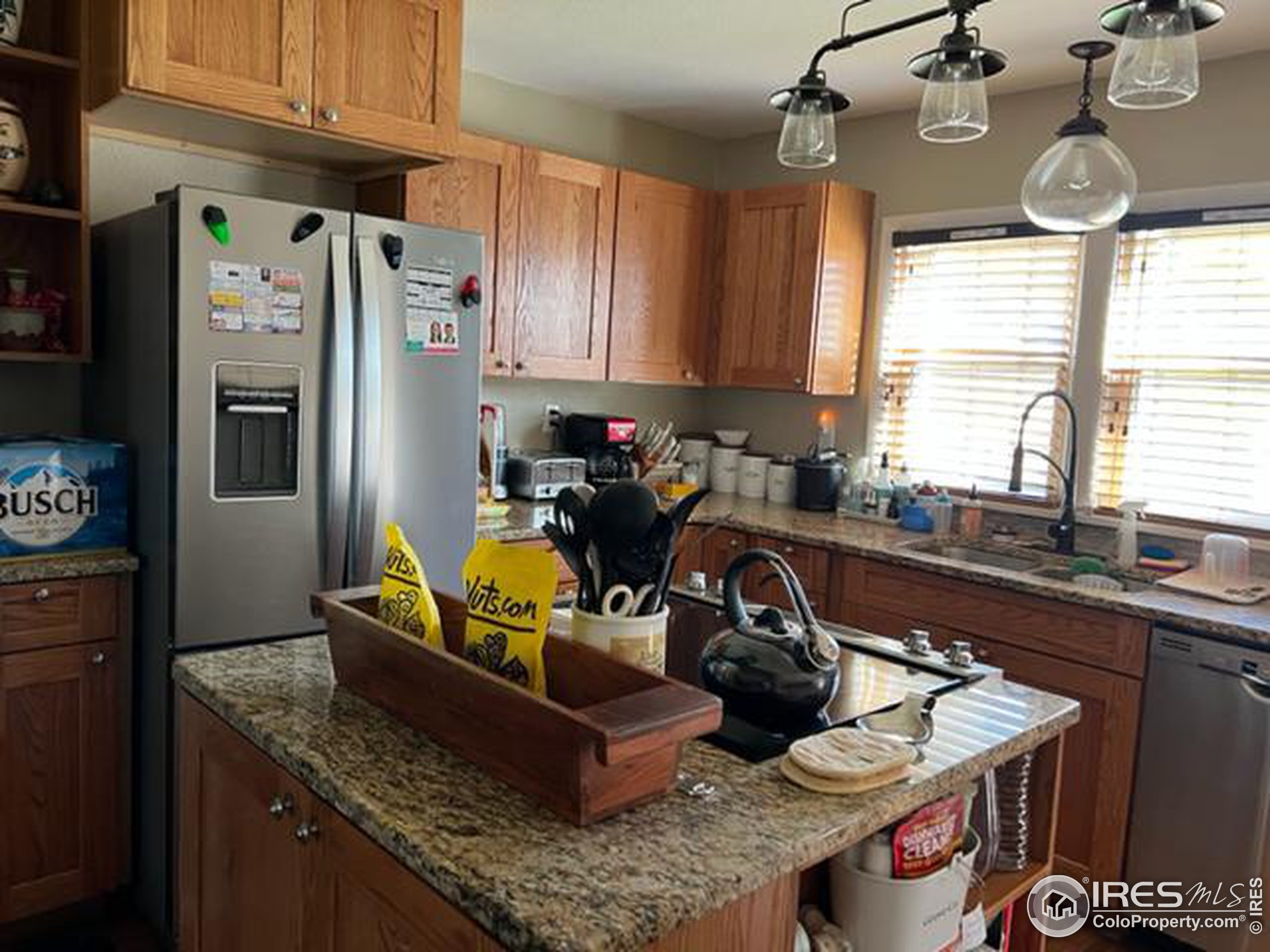 1124 West 7th Street Wray, CO 80758 - Photo 9 of 11 a kitchen with granite countertop a refrigerator a stove a sink and dishwasher