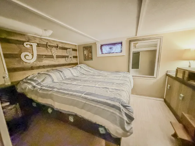 a bedroom with a bed and a tv on table