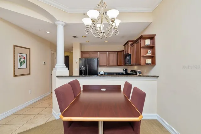 a dining room with wooden floor and a chandelier