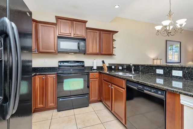 a kitchen with stainless steel appliances granite countertop a refrigerator a stove a sink and a microwave