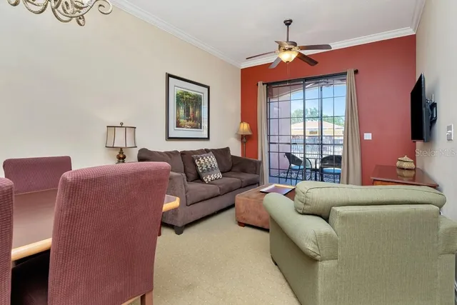 a living room with furniture a ceiling fan and a window