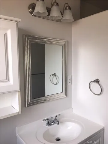 a bathroom with a sink vanity and mirror