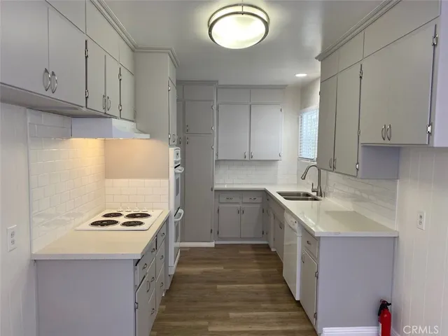 a kitchen with granite countertop a sink stove and cabinets