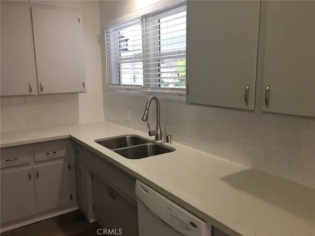 a kitchen with a sink cabinets and window