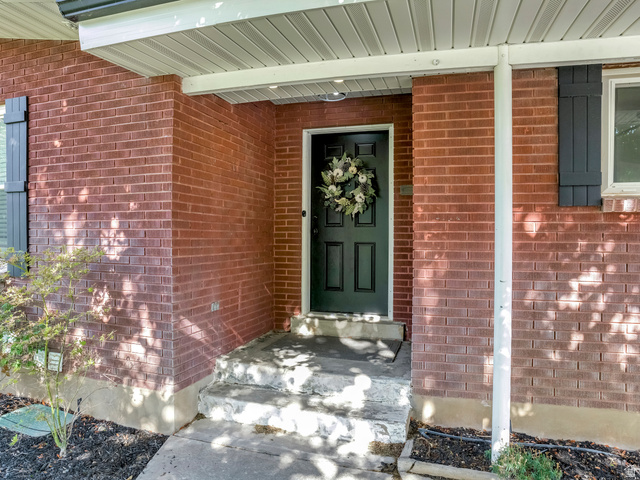 523 South Main Street Payson, UT 84651 - Photo 7 of 41 Brick exterior featuring a covered entry, dark paneled front door, and decorative window shutters