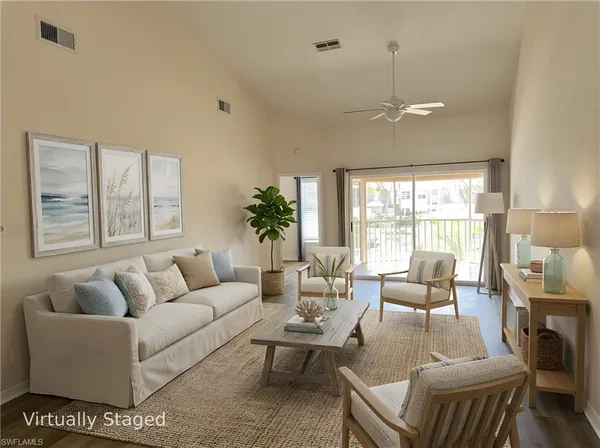 a living room with furniture a large window and a chandelier