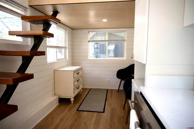 a view of a hallway with wooden floor and staircase
