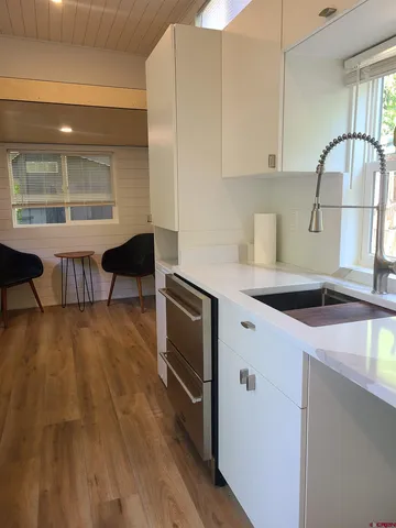 a kitchen with stainless steel appliances granite countertop a sink a stove and a wooden floors