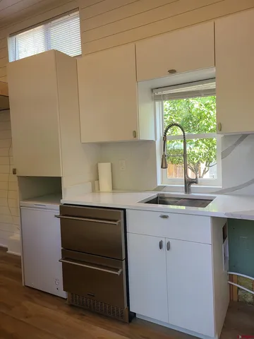 a kitchen with a sink a window and cabinets