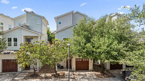 a front view of a house with a tree