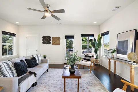 a living room with furniture potted plant and a large window