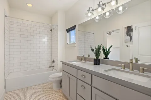 a bathroom with a granite countertop sink a toilet and a bathtub