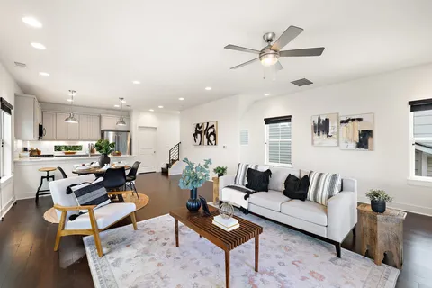 a living room with furniture kitchen view and a window