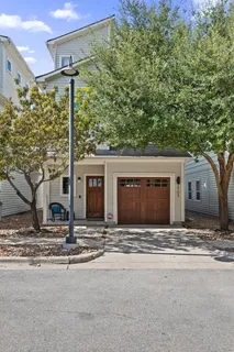 a view of a house with a yard and large tree