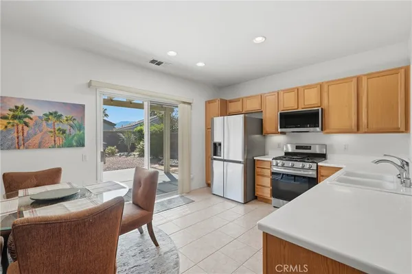 a kitchen with stainless steel appliances granite countertop a refrigerator stove top oven a sink and dishwasher