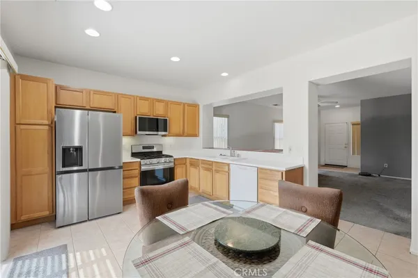 a kitchen with stainless steel appliances wooden floor and large windows