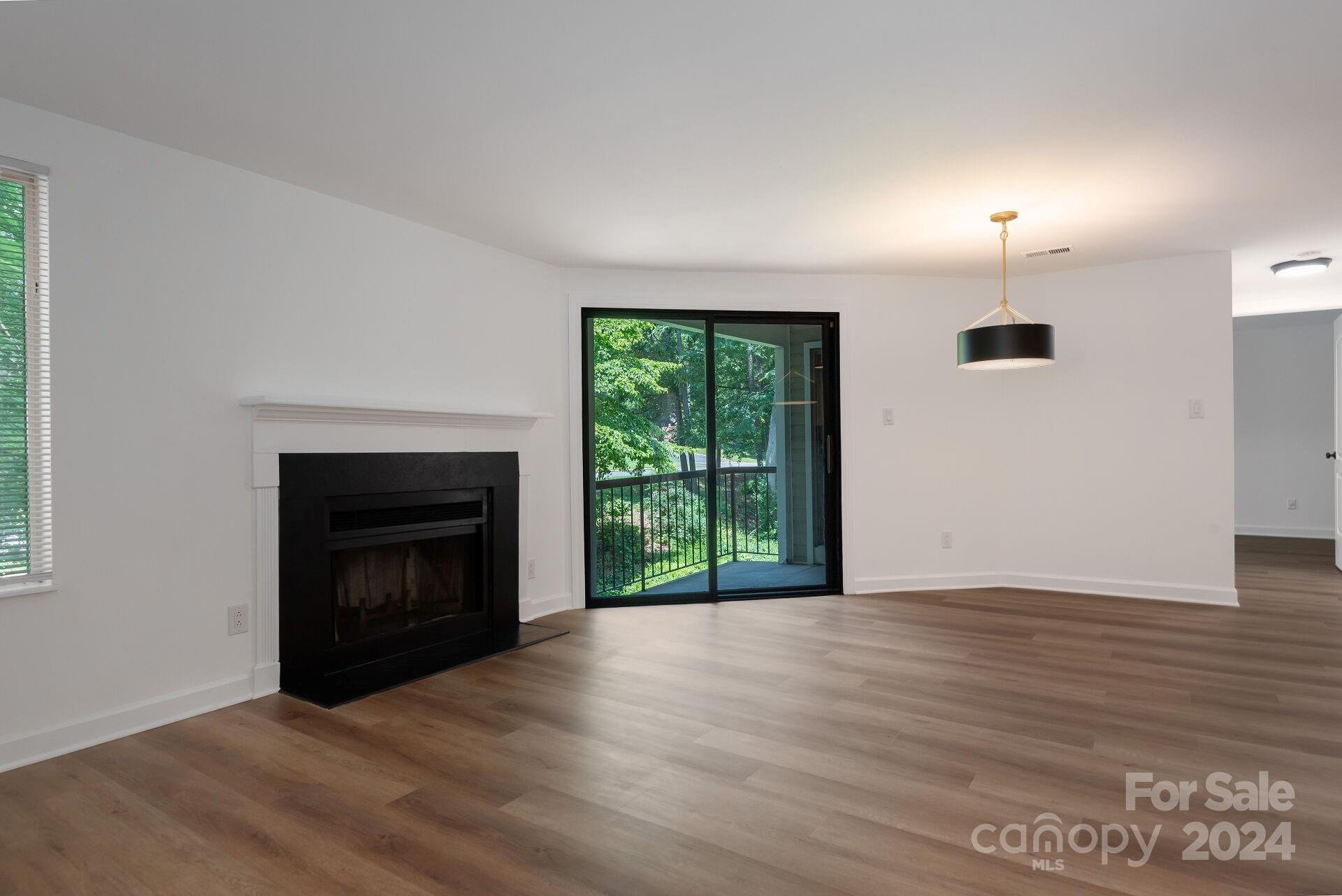 a view of empty room with wooden floor and fireplace