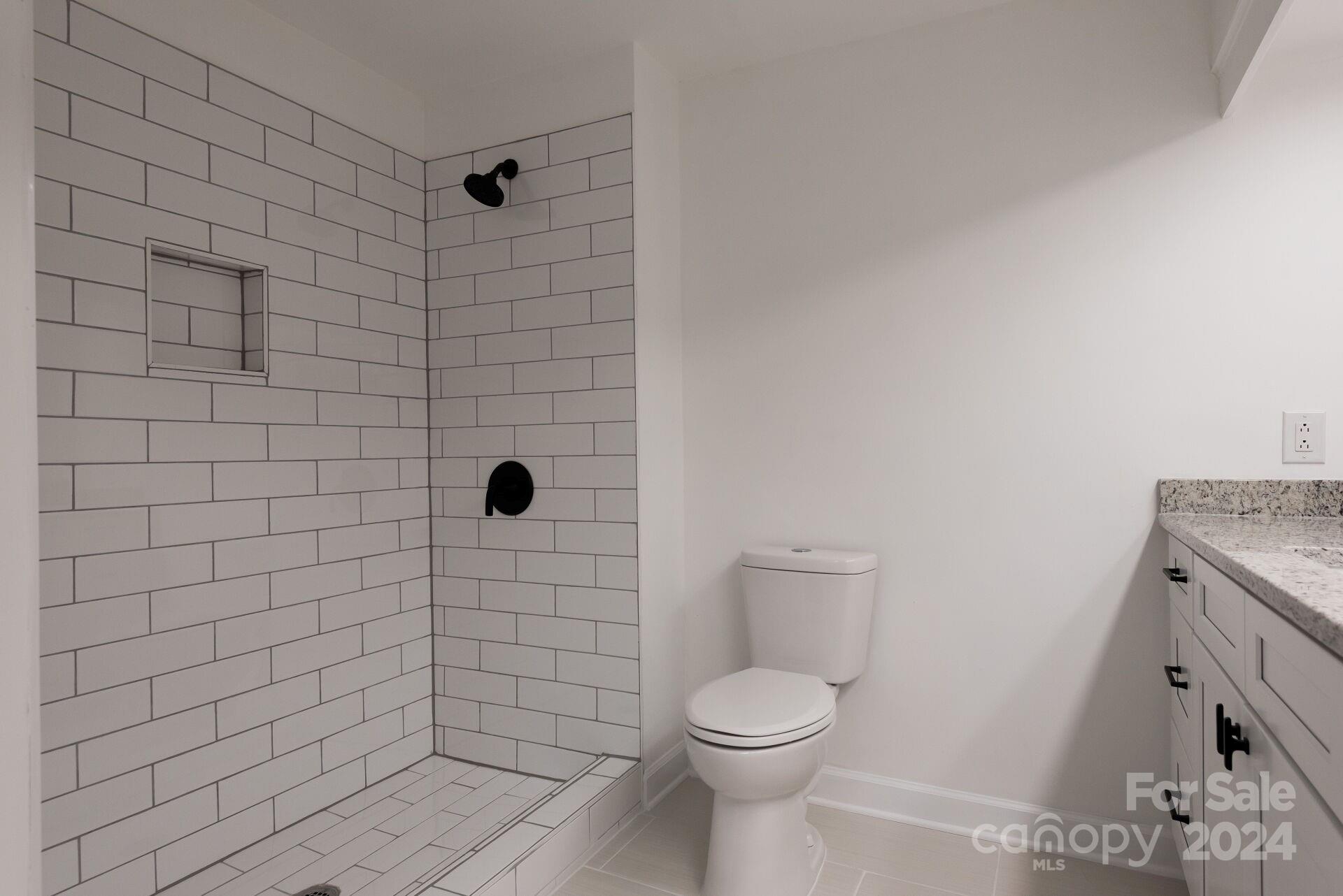 7516 Pebblestone Drive, Unit E Charlotte, NC 28212 - Photo 11 of 21 a bathroom with a toilet and a shower