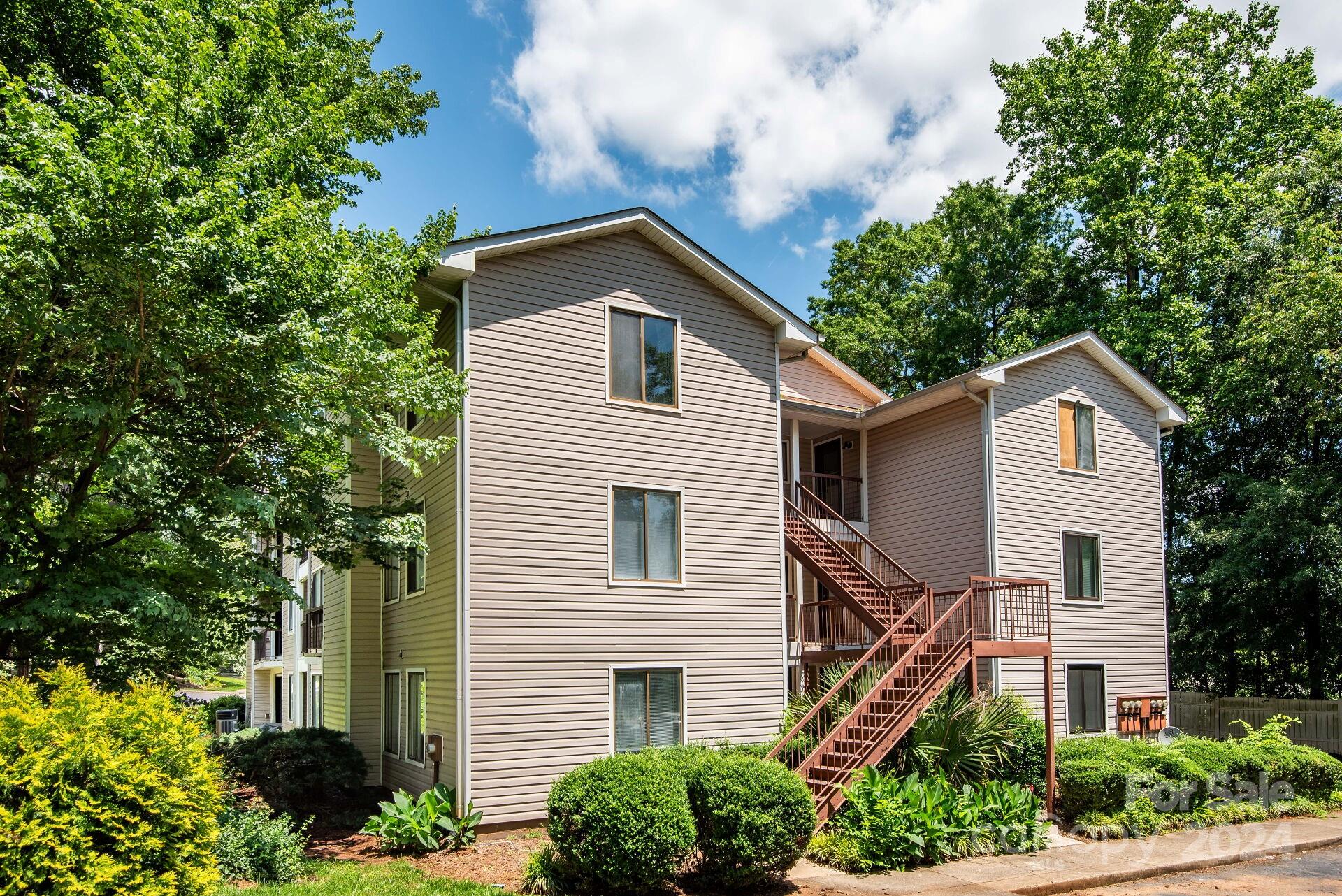 7516 Pebblestone Drive, Unit E Charlotte, NC 28212 - Photo 19 of 21 a front view of a house with a yard and trees