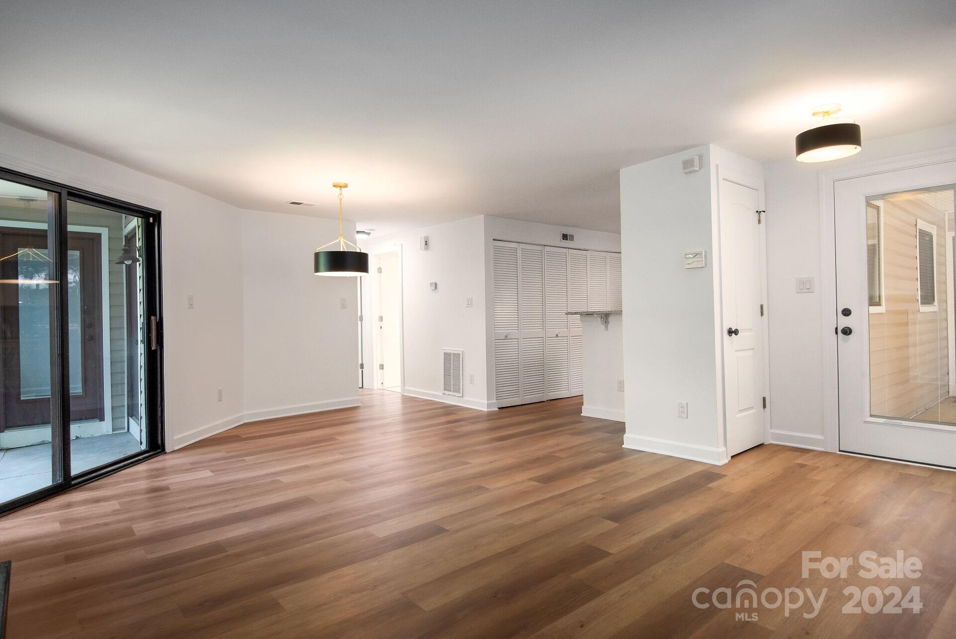 7516 Pebblestone Drive, Unit E Charlotte, NC 28212 - Photo 2 of 21 an empty room with wooden floor and windows