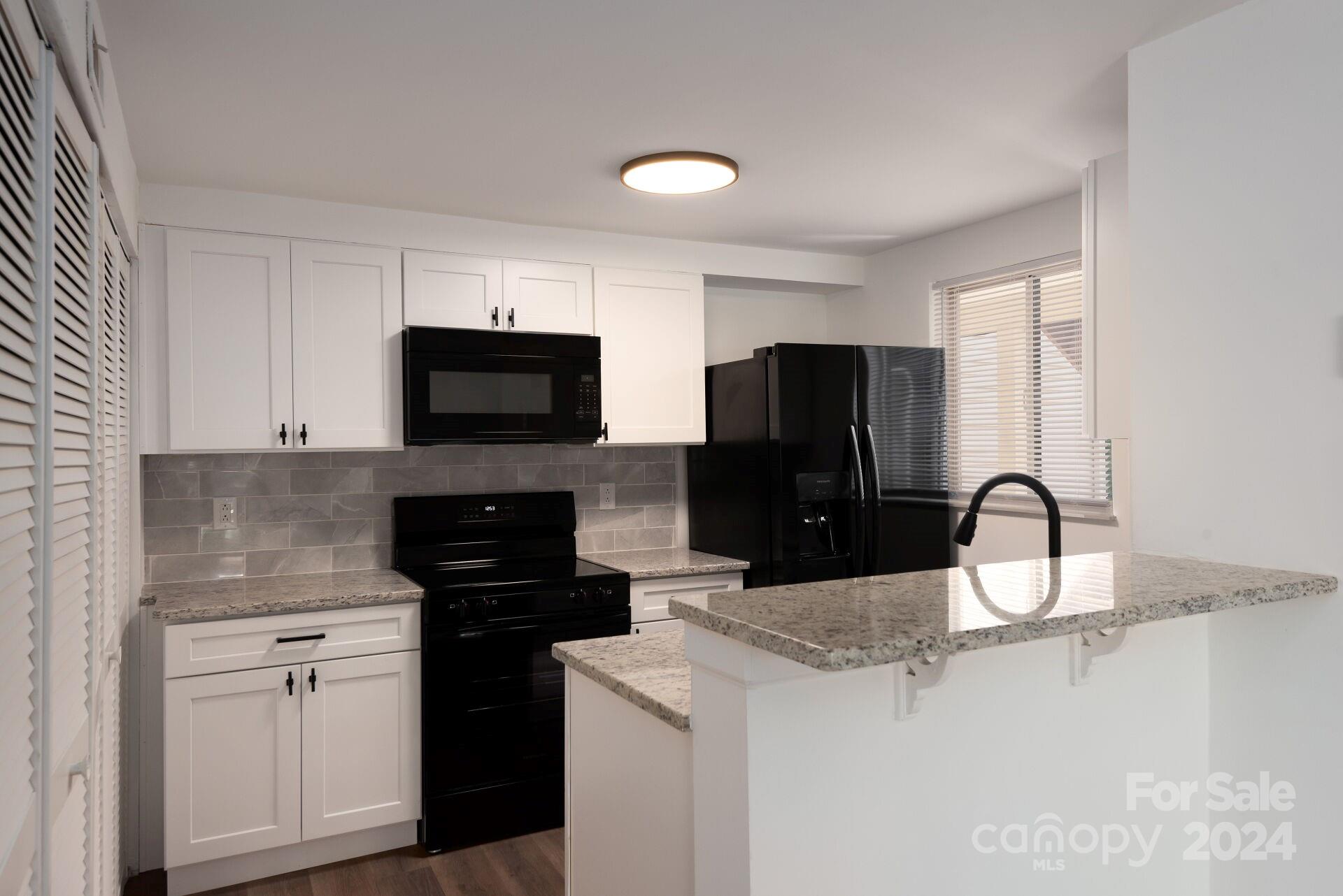 7516 Pebblestone Drive, Unit E Charlotte, NC 28212 - Photo 5 of 21 a kitchen with a sink a stove and refrigerator