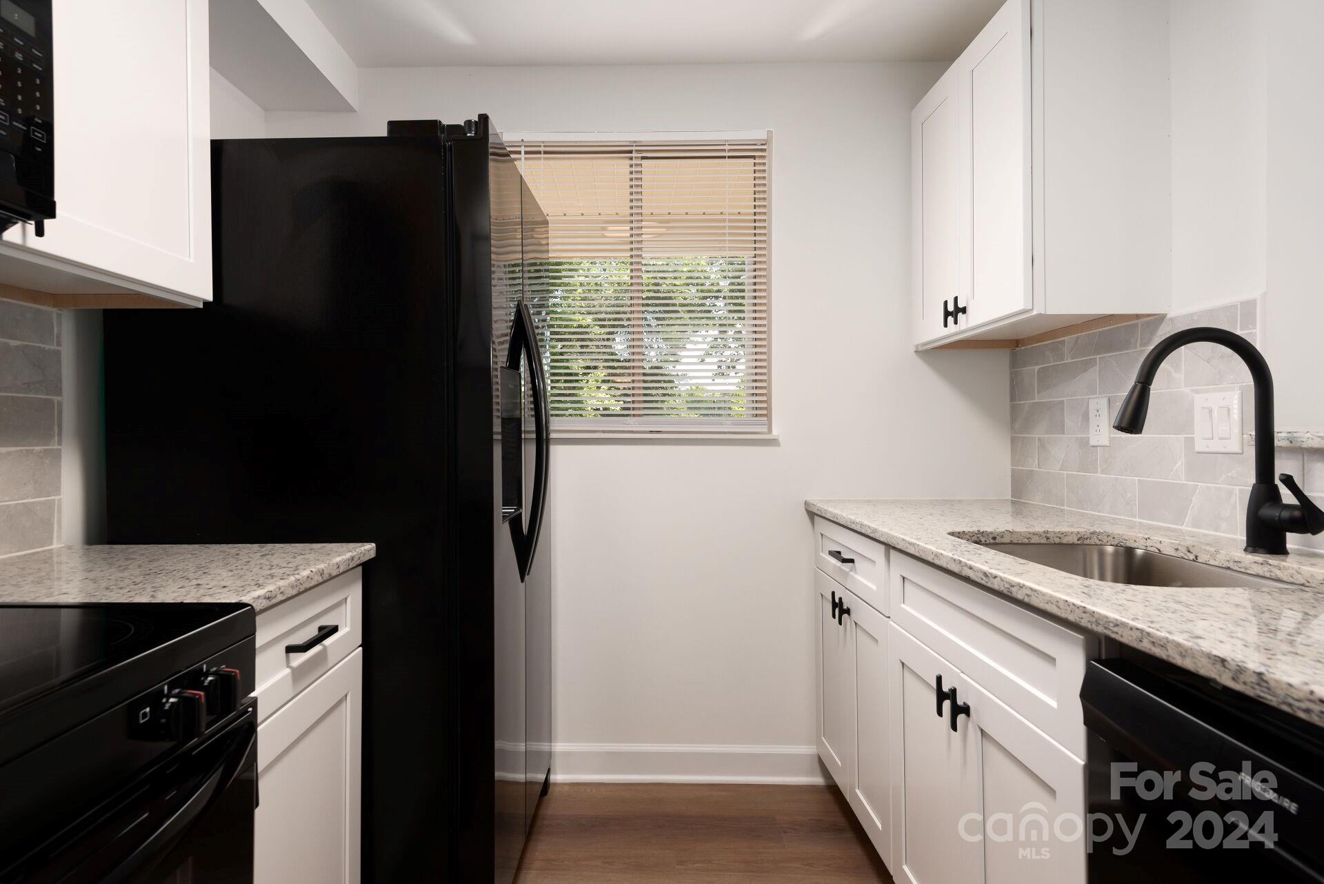 7516 Pebblestone Drive, Unit E Charlotte, NC 28212 - Photo 6 of 21 a kitchen with a sink and a refrigerator
