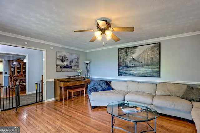 a kitchen with stainless steel appliances granite countertop a refrigerator a stove top oven a sink dishwasher and white cabinets with wooden floor