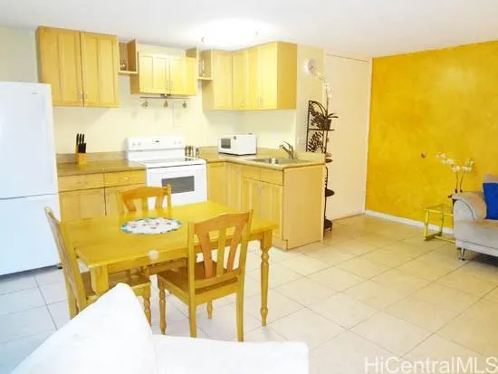a kitchen with stainless steel appliances a stove a refrigerator a sink and white cabinets with wooden floor